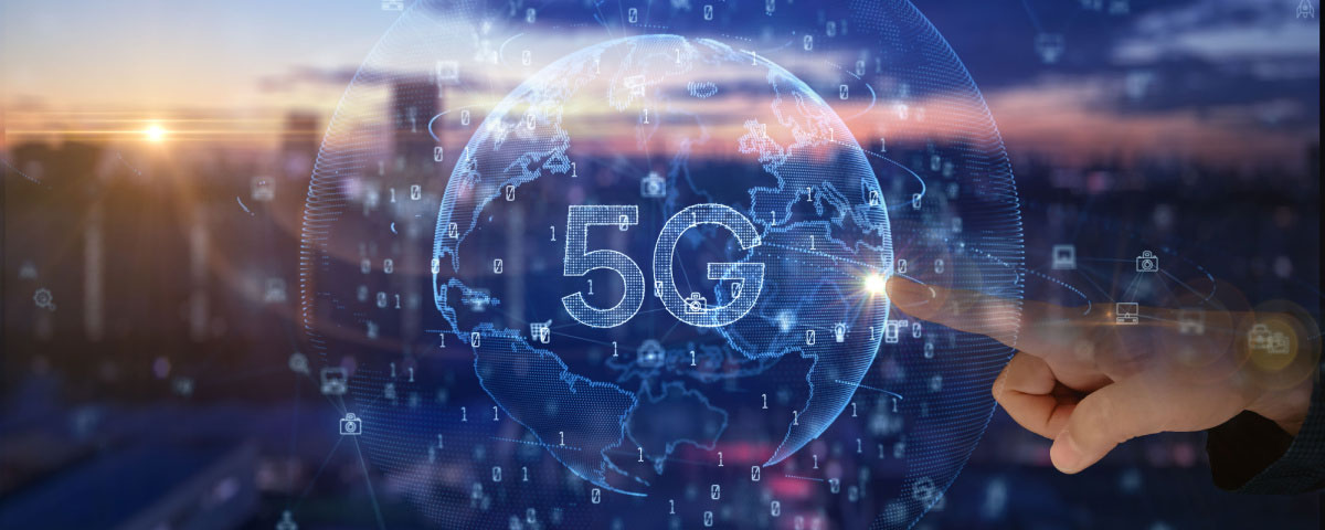 Virtual globe with 5G on it and a finger touching it with a blurred view of a city skyline in the background