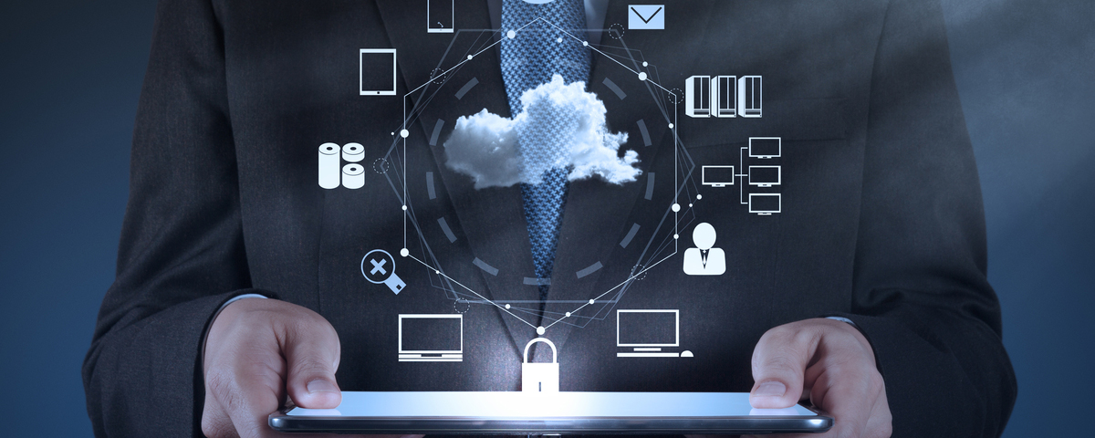 Man in suite holding laptop with cloud and computer icons floating above it