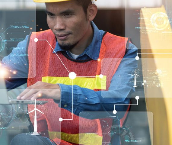 Engineer in factory on laptop using AI for maintenance tasks