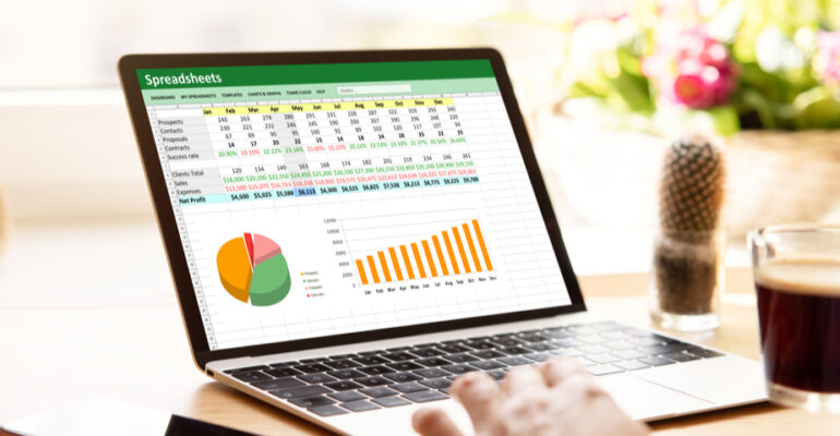 Close up of laptop on desk in home office with a spreadsheet application displayed