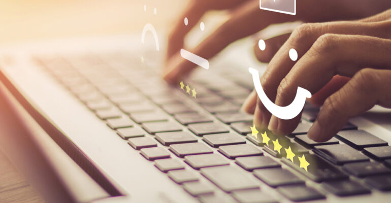 Hands typing on laptop keyboard with overlay of review icons