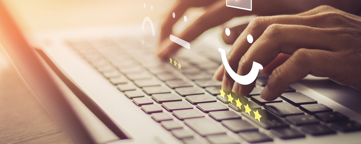 Hands typing on laptop keyboard with overlay of review icons