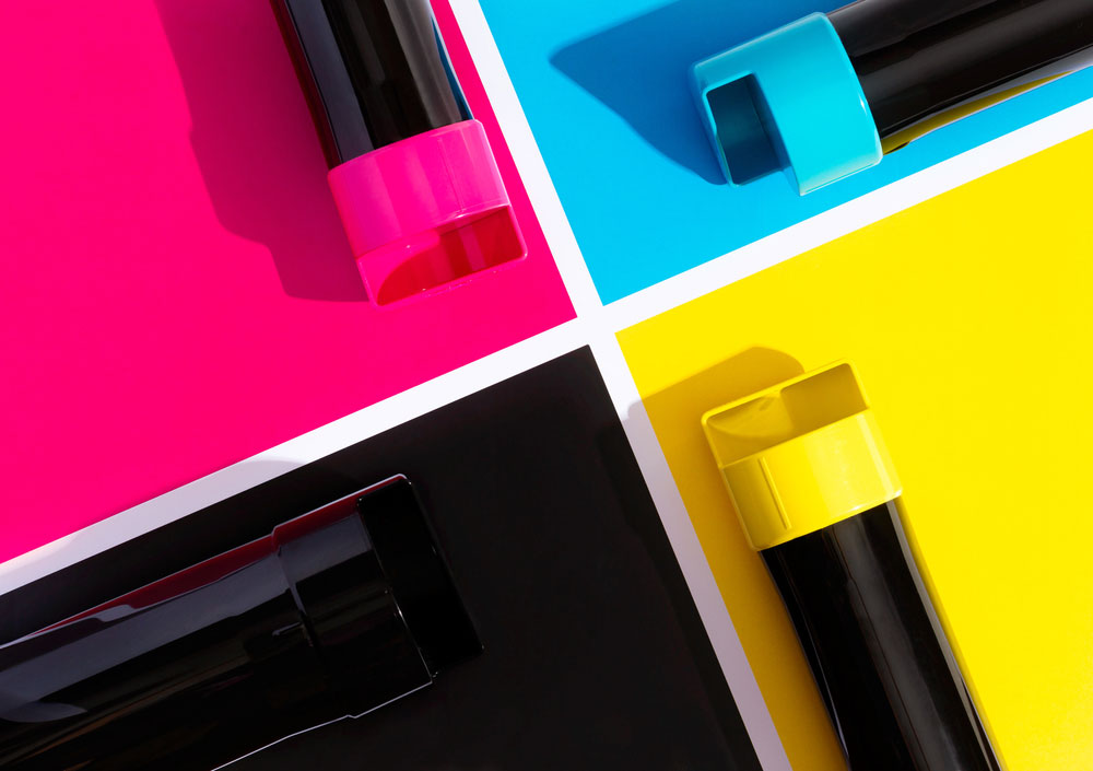 Close up of a set of toner cartridges with a color block background