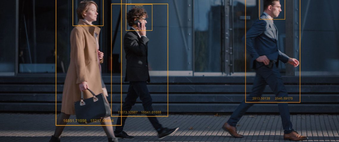 People walking on a sidewalk with tracking technology frames around them