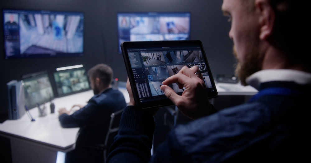Security person holding tablet and using fingers to zoom in on a section of the screen